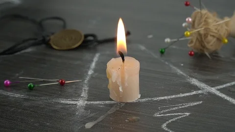 A burning candle on a magic circle next to occult needles. Stock Footage 123895895