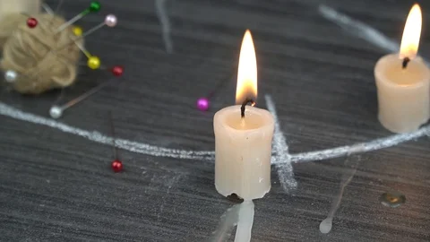 A burning candle on a magic circle next to occult needles. Stock Footage 124767850