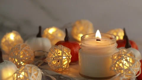 Burning candle on marble tray with pumpkins and warm lights, cozy home, min.. Stock Footage 253576196