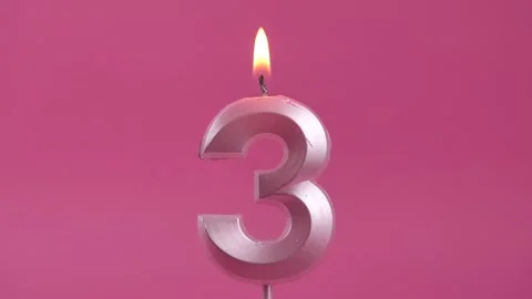 Burning candle with number 3 on a pink background. birthday party. Stock Footage 274843299