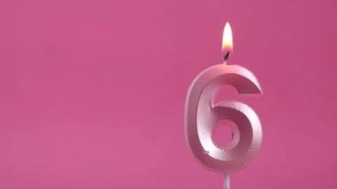 Burning candle with number 6 on a pink background. Copy space. place for text. Stock Footage 274676151