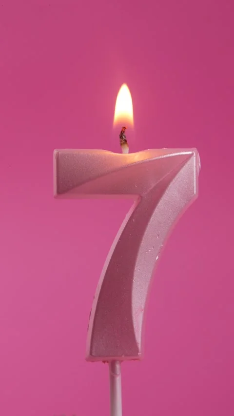 Burning candle with number 7 on a pink background. vertical screen. Stock Footage 274479269