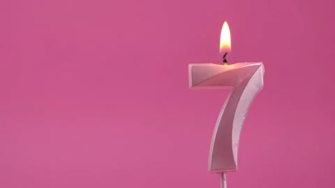 Burning candle with number 7 on a pink background. Copy space. place for text. Stock Footage 274675980
