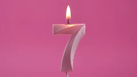 Burning candle with number 7 on a pink background. Stock Footage 274843412