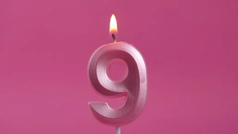 Burning candle with number 9 on a pink background. birthday party Stock Footage 274843586