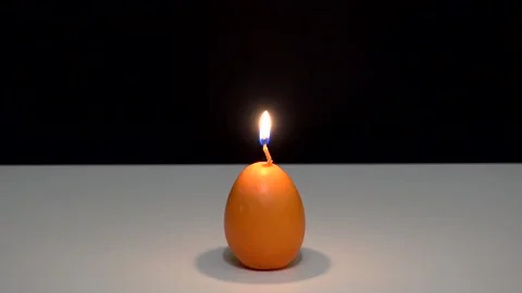 A burning candle in the shape of an egg Video stock 159436060