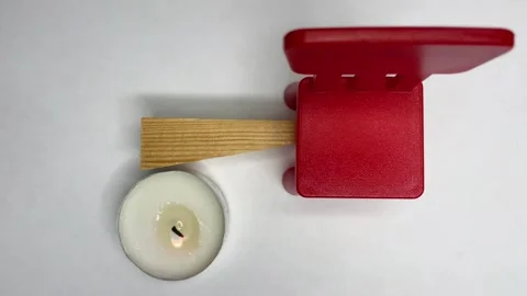 A burning candle stands next to a chair on a white background Video stock 252188674