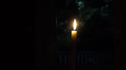 Burning candle on the table against the background of the yard Stock Footage 242542314