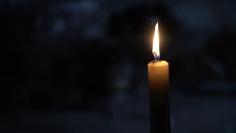 Burning candle on the table against the background of the yard Stock Footage 242542373