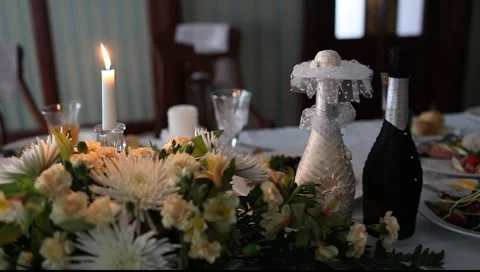 Burning candle on wedding table, decorated bottles in shadow Видео 990677