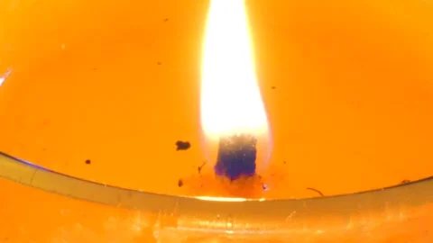 Burning candle wick flame in melted orange liquid wax close up Stock-Footage 335842693