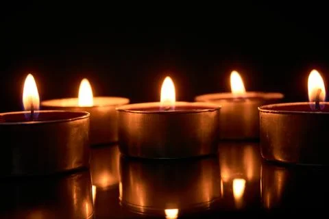 Burning candles on a black background, selective focus, romantic setting, a.. Stock Photos