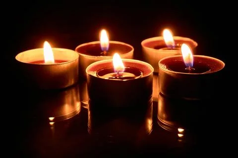 Burning candles on a black background, selective focus, romantic setting, atm Stock Photos
