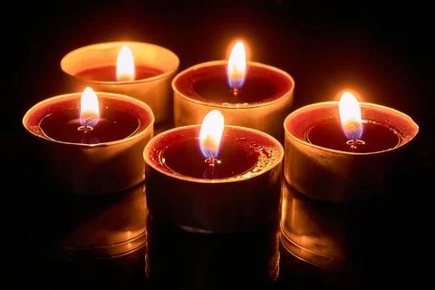 Burning candles on a black background, selective focus, romantic setting, atm Stock Photos