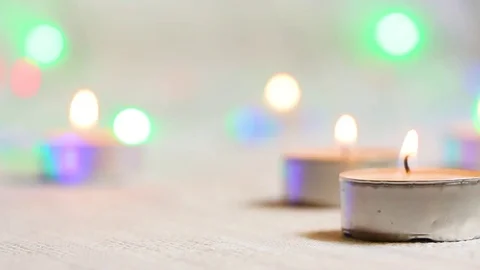 Burning candles close-up against a background of shimmering flashlights in light Stock Footage 82407506