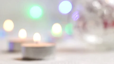 Burning candles close-up against a background of shimmering flashlights in light Video stock 82407539