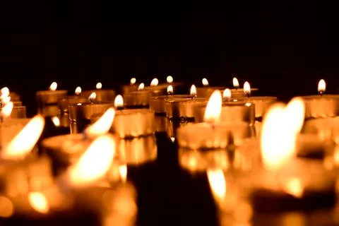 Burning candles on a dark background with reflection. Stock Photos