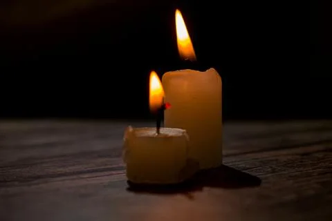Burning Candles in Dark Moody Setting with Warm Flame Light Foto stock