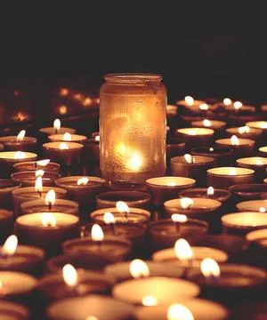 Burning candles on dark surface. Memory day Stock Photos