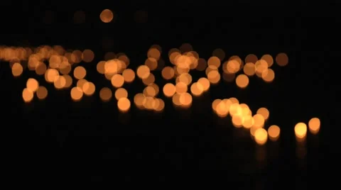 Burning candles float on water at Loi Khrathong celebration. Deep out of focus. Video stock 49537439