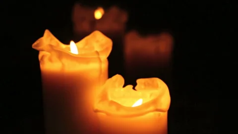 Burning candles in front of black background Stock Footage 242423798