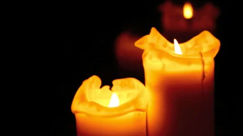 Burning candles in front of black background Stock Footage 242423821