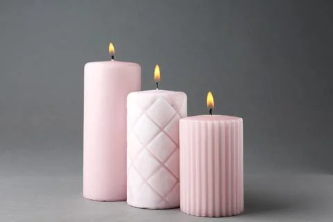 Burning candles on grey background. Interior elements Foto stock