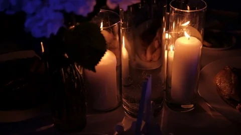 Burning candles inside glass flasks stand on table in room. Video stock 82158751