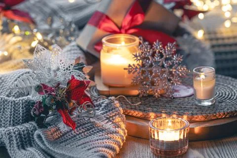 Burning candles, knitted elements and Christmas decor details. Foto stock