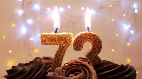 Burning candles made in the shape of a number 73 on a birthday cake Stock Footage 105448740