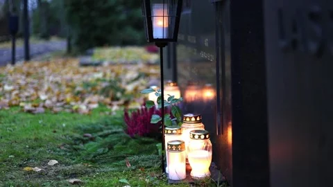 Burning candles placed on graves in a quiet cemetery, 4K ultra HD. Stock Footage 320641731