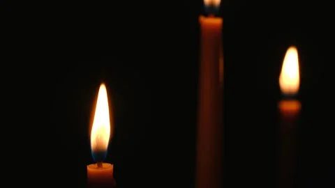 Burning candles providing light in darkness with blurred candle in background Stock Footage 312982244