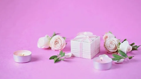 Burning candles , quivering flame, a box with a gift, rosebuds and falling petal Stock Footage 111461739