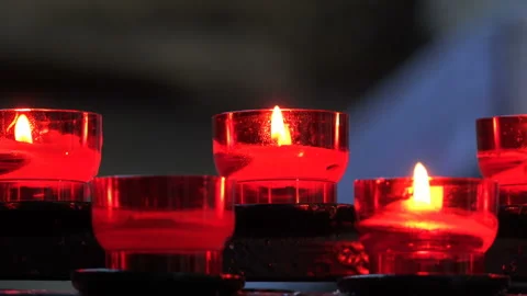 Burning candles in red candlesticks in the temple Stock Footage 93176443