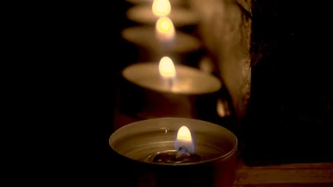 Burning candles in a row on fireplace in the dark Stock Footage 96328448