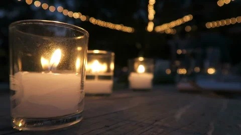 Burning candles sit on an outdoor ￼table￼ for the evenings event￼￼. Stock Footage 119077473