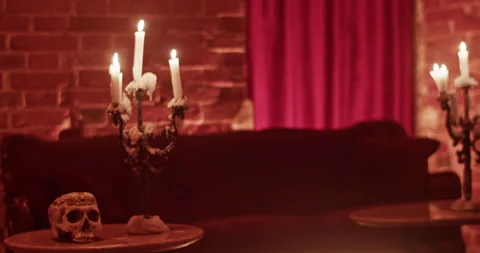Burning candles with spooky skull on table at home Stock Footage 260558395