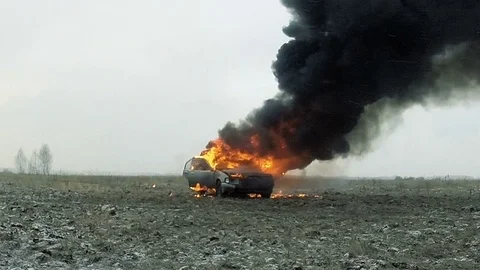 Burning car in the field Stock Footage 81439144