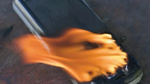 Burning cell phone lying on the table Video stock 209124273