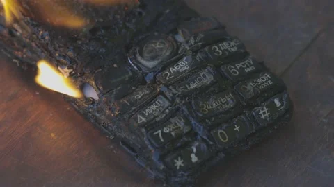 Burning cell phone lying on the table Video stock 209124289