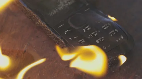 Burning cell phone lying on the table Video stock 209124315