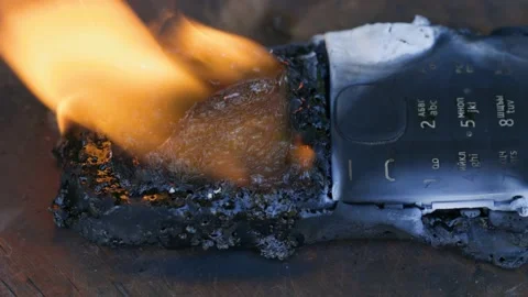 Burning cell phone lying on the table Video stock 209124328