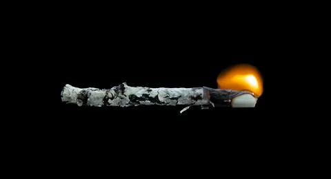 Burning cigarette on black background. Stock Photos