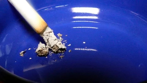 Burning cigarette in a blue ashtray close up footage. Stock Footage 86596203