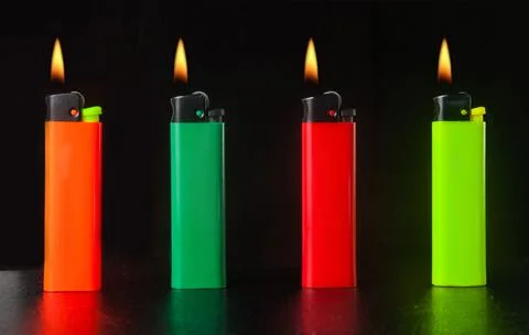 Burning cigarette lighter on a black background Stock Photos