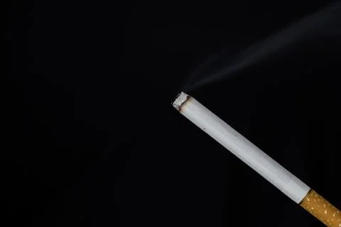 Burning cigarette with smoke on black background Stock Photos