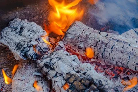 Burning coals from logs on the fire. The wind blows the burning fire Stock Photos