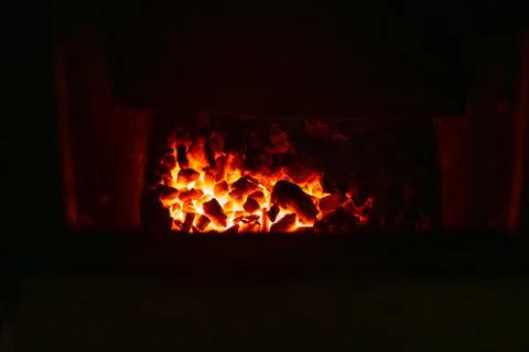 Burning coals in a solid fuel boiler. Heating of a residential building in wi Fotos de archivo