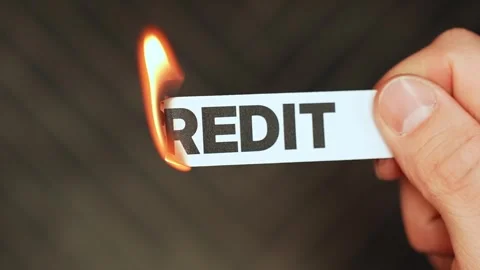 Burning “credit” label held by hand, symbolizing debt freedom, cash-based Stock Footage 333655807