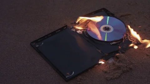 Burning data disc on the sand at coast Video stock 74364192